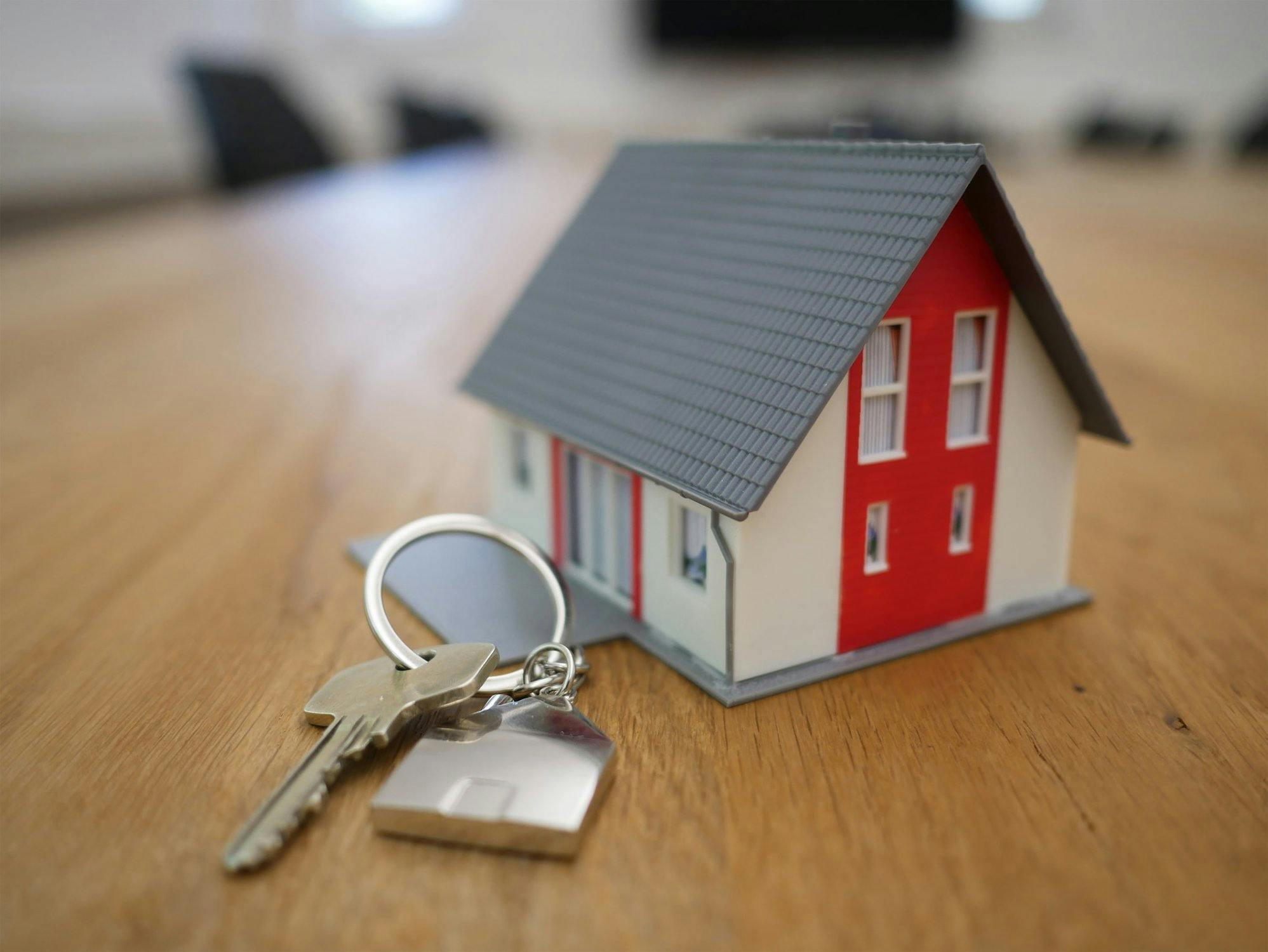 Schlüssel neben einem Miniaturhaus