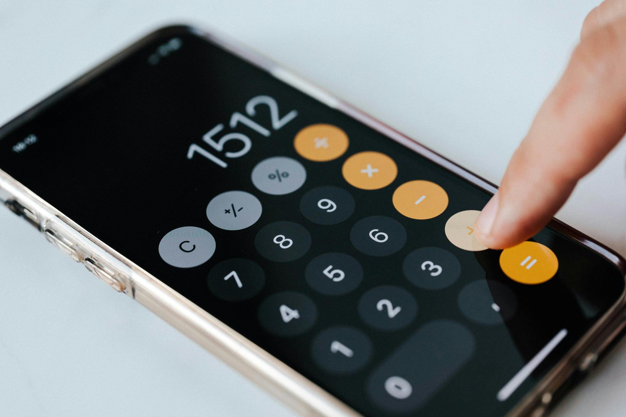 Ein Finger, der eine Taschenrechner-App auf einem Smartphone bedient